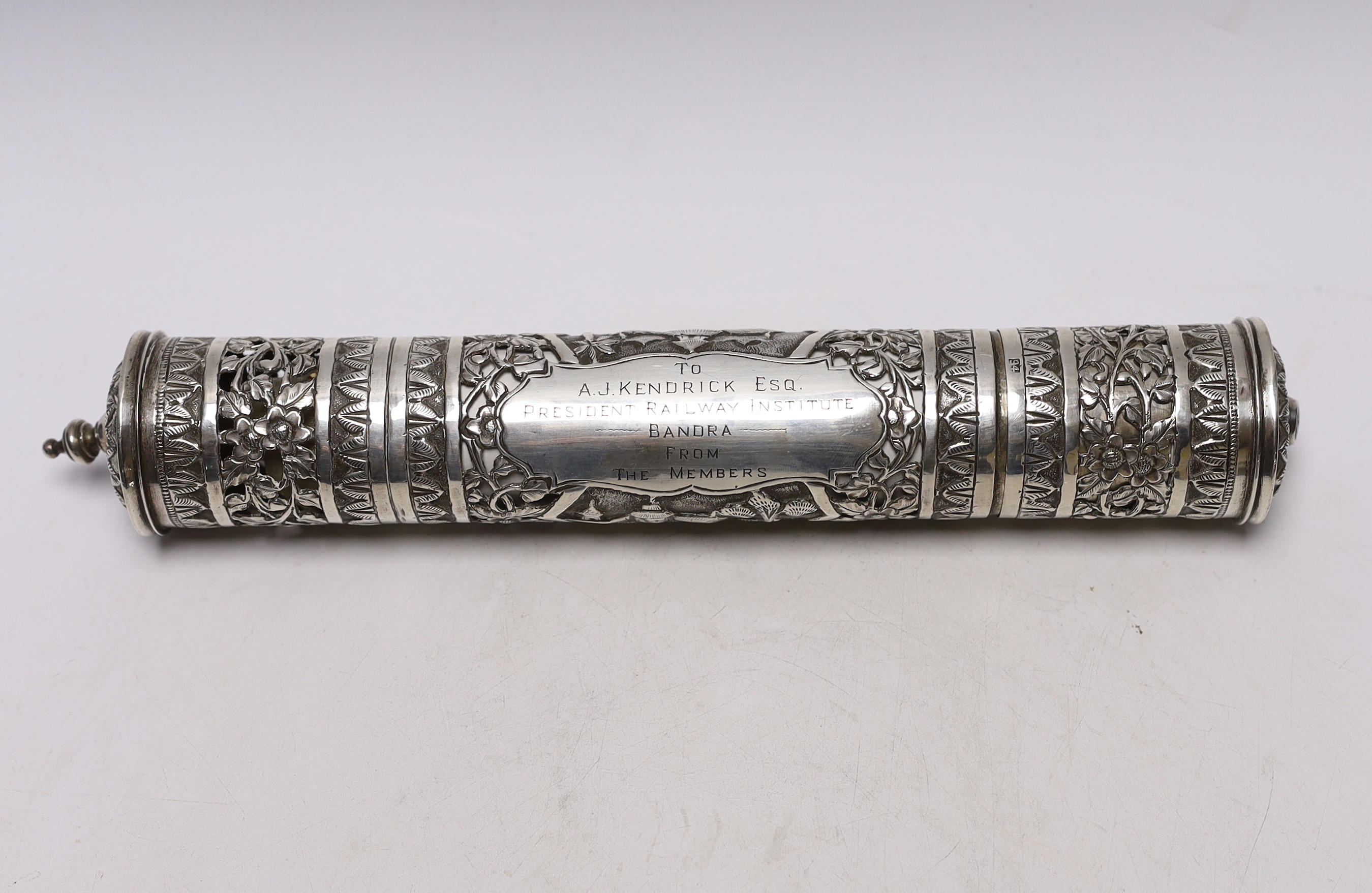 A mid 20th century Indian pierced white metal presentation scroll case to 'To A.J. Kendrick Esq. President Railway Institute Bandra, From The Members', 31.7cm, containing a silk scroll dedicated to the recipient